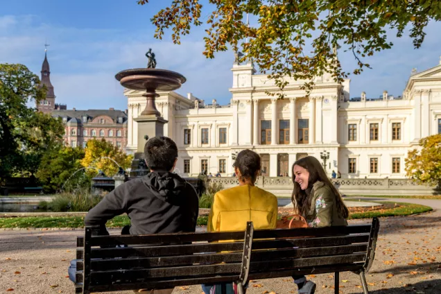 students sitting by the fountain in Lundagård. Photo.