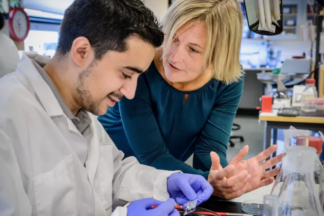 Photo of Malin and a student in the lab.